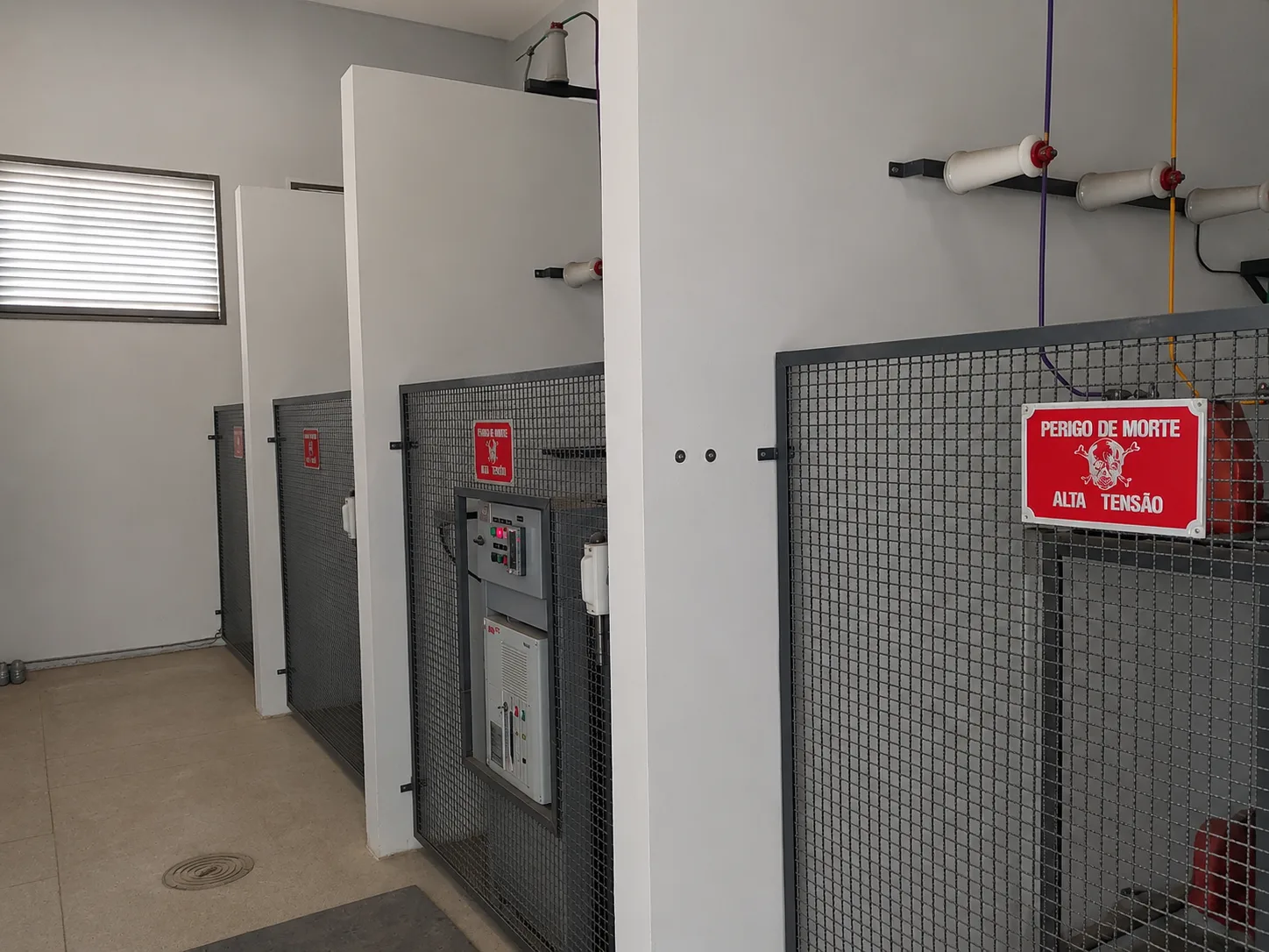Sala de cabine primária de média tensão executada pela Godoy Engenharia, com cubículos protegidos e sinalização de alta tensão
